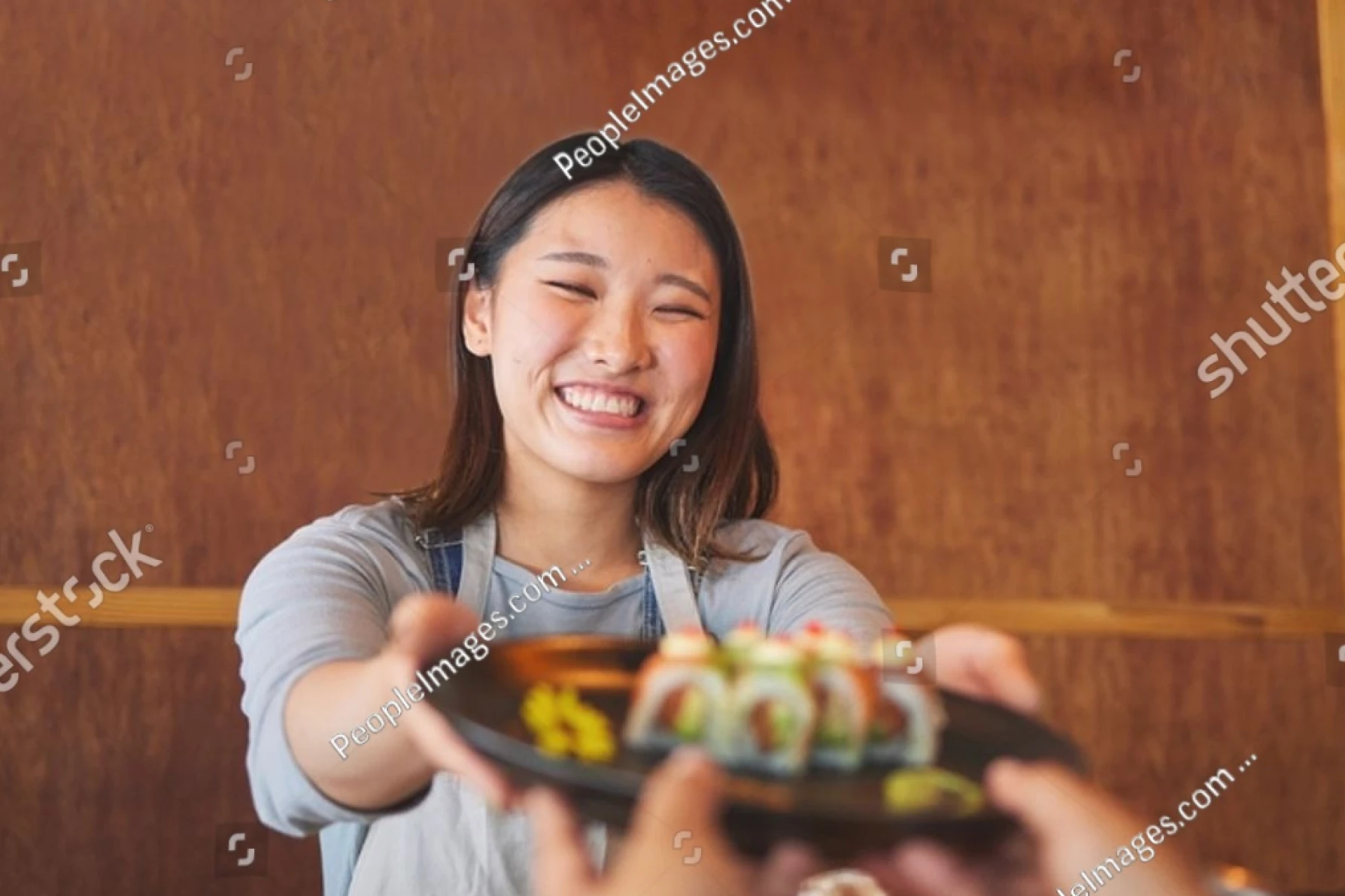 笑顔で料理を持つ女性